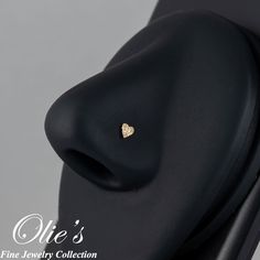 a close up view of a nose with a gold heart on it's side