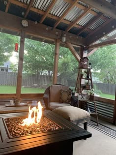 a fire pit in the middle of a covered patio