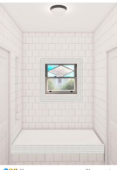 a white tiled room with a window and bench