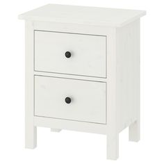 a white nightstand with two drawers and black knobs on the bottom, against a white background