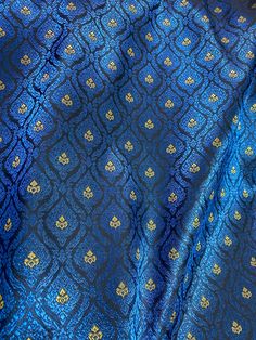 blue and gold fabric with an intricate design on it's side, close up