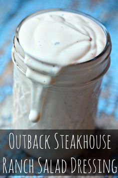 a jar filled with ranch salad dressing sitting on top of a blue cloth covered table