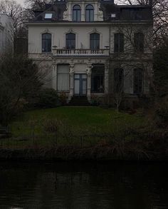 an old house sitting next to a body of water