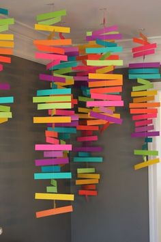 colorful paper streamers hanging from the ceiling in a room with gray walls and white trim