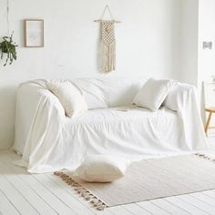 a living room with white furniture and pillows