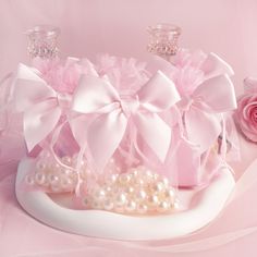 a tiara with pink bows and pearls on it next to a bouquet of flowers