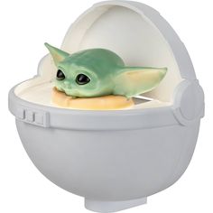 a baby yoda toy is in an egg shell with its head inside the eggshell