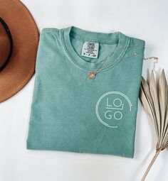 a hat, t - shirt and feather on a white table with the logo go