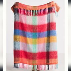 a multicolored blanket with fringes hanging from it's end on a white background