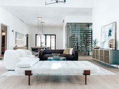 a living room filled with furniture and a wine rack on the wall in the background