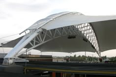 a large white structure sitting on the side of a road next to a train track