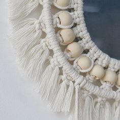 a close up of a mirror with tassels on it