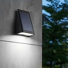 a solar powered light mounted on the side of a building