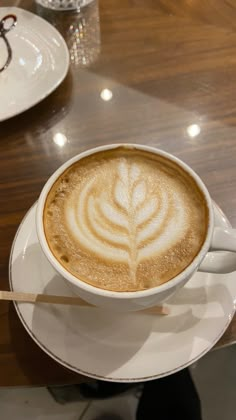 a cappuccino is sitting on a saucer