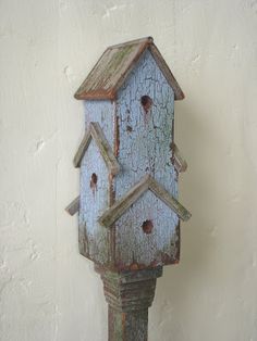 a blue birdhouse with holes in it's roof is hanging on the wall