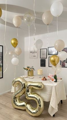 the table is decorated with balloons and gold numbers