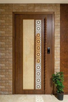 a wooden door with decorative glass panels and a potted plant