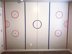 an empty room with three hockey rinks painted on the walls and two red white and blue lines