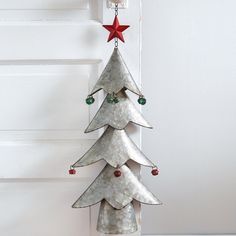 a metal christmas tree hanging from the side of a door