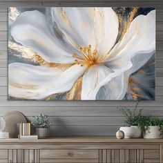 a large white flower with gold accents on a wall above a dresser in a living room