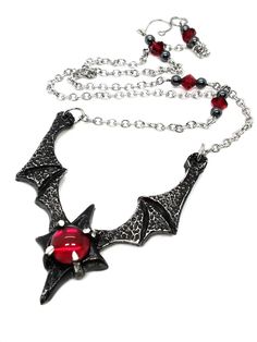 Made to Order! Dramatic, imposing and vampiric as you are, this bat wing necklace will complete your nocturnal ensemble. Stalk the halls of your dwelling or favorite events and capture the attention of your fellow night creatures with its unique design, sculpted in our studio. The pendant is cast in lead free pewter by Gothic Winged Jewelry For Gifts, Gothic Winged Jewelry Gift, Vampire Style Necklaces For Halloween Cosplay, Vampire Style Necklace For Halloween, Gothic Red Necklace For Cosplay, Red Gothic Necklace For Cosplay, Handmade Vampire Necklaces For Halloween, Gothic Horned Jewelry For Halloween, Handmade Gothic Horned Jewelry