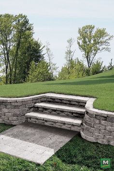 a stone bench sitting on top of a lush green field