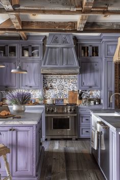 a kitchen with purple cabinets and wooden floors