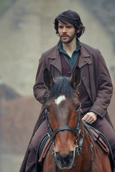 a man riding on the back of a brown horse