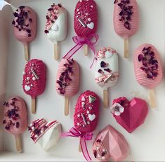 pink and white lollipops with hearts on them are arranged in a box