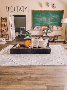 a living room filled with furniture and a chalkboard