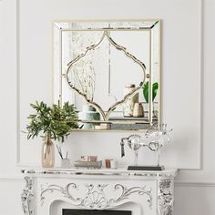 a fireplace with a mirror above it and a potted plant on the mantel