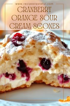 a close up of a piece of cake on a plate with the words cranberry orange sour cream scones