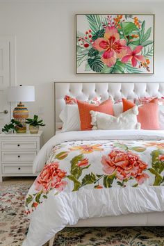 a white bed topped with lots of pillows next to a painting on the wall above it