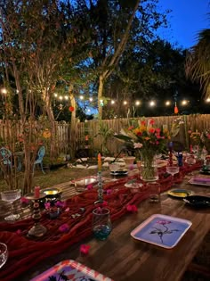 an outdoor dinner table set up with candles and plates for two people to eat at