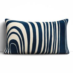 a blue and white striped pillow sitting on top of a wall