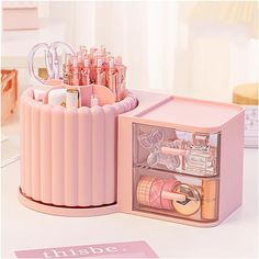 a pink box filled with lots of items on top of a white table next to a mirror