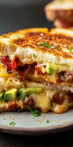 a grilled cheese sandwich with bacon, avocado and tomato on a plate