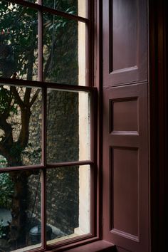 an open window with a view of a tree outside