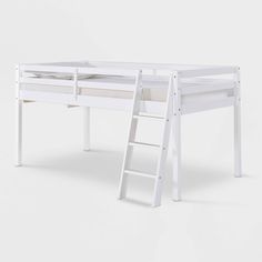 a white bunk bed with a ladder next to it and a desk underneath the bed