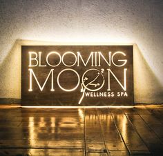 a lighted sign that reads blooming moon with the words wellness spa on it