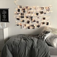 a bed room with a neatly made bed and string lights hanging from the wall above it