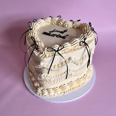 there is a cake that has been decorated with black and white ribbons on the top