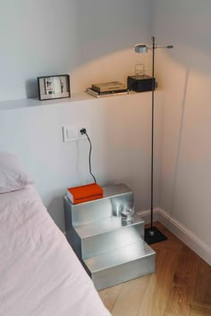 a bed room with a neatly made bed and a shelf on the wall next to it