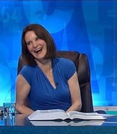 a woman sitting at a desk with an open book in front of her on the news