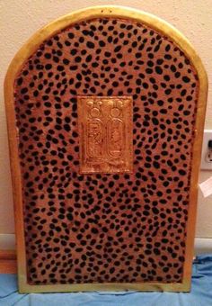 an animal print and gold plated object on a blue cloth covered tablecloth next to a wall