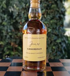 a bottle of groomsman's whiskey sitting on top of a checkered table