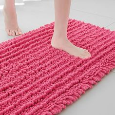 a person standing on top of a pink rug