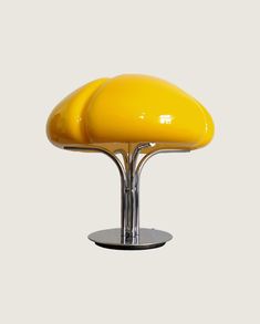 a yellow table lamp sitting on top of a metal stand