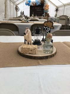 the table is set up for an event with decorations on it and candles in glass bottles