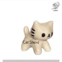 a white ceramic cat with black eyes on it's face and the words cat stand